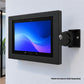 A black tablet display mount bracket mounted on a light gray wall, holding a tablet frame.